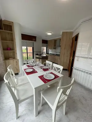 a white dining table and chairs in a kitchen at Alojamiento Apostol 2 in Melide