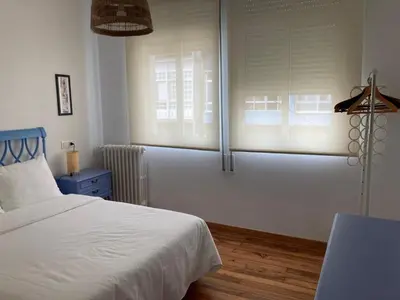 a bedroom with a white bed and two windows at Casa Morín, apartamento Ribeira Sacra in Monforte de Lemos