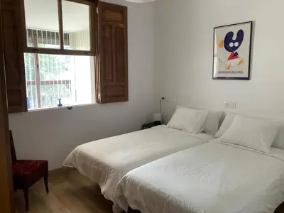 a bedroom with two beds and a window at Casa Morín, apartamento Ribeira Sacra in Monforte de Lemos