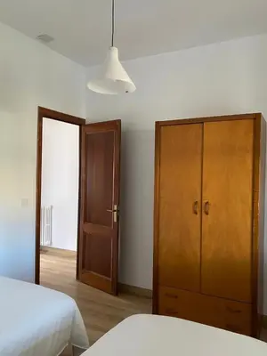 a bedroom with a bed and a wooden cabinet at Casa Morín, apartamento Ribeira Sacra in Monforte de Lemos