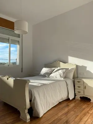a white bedroom with a large bed and a window at Casa Morín, apartamento Ribeira Sacra in Monforte de Lemos