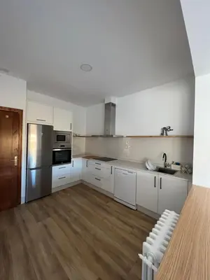 a kitchen with white cabinets and stainless steel appliances at Casa Morín, apartamento Ribeira Sacra in Monforte de Lemos