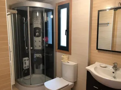 a bathroom with a shower and a toilet and a sink at Apartamento para 6 personas con piscina y paddle in Foz