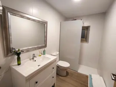 a white bathroom with a sink and a toilet at A casa do lajueiro in Arzúa