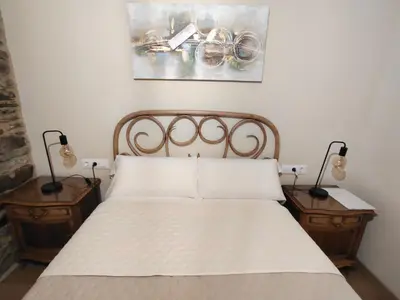 a bedroom with a bed with two night stands and two lamps at A casa do lajueiro in Arzúa