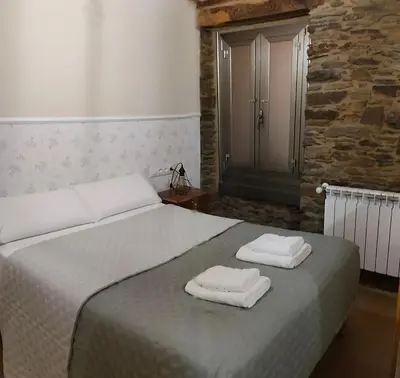 a bedroom with a bed with two towels on it at A casa do lajueiro in Arzúa