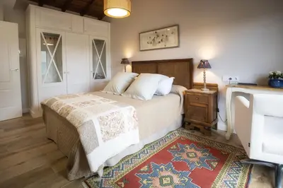 a bedroom with a bed and a table with a rug at Casa Regente in O Viso