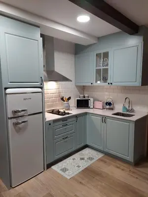 a kitchen with blue cabinets and a white refrigerator at Casa Regente in O Viso