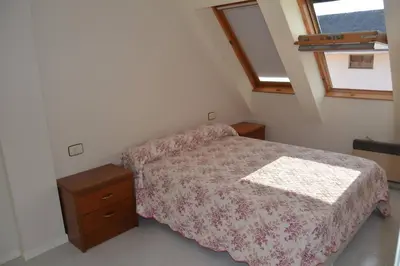 a bedroom with a bed and a dresser and a window at Precioso ático a pie de playa, en Miño. in Miño
