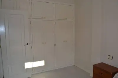 a white closet with white walls and white cabinets at Precioso ático a pie de playa, en Miño. in Miño