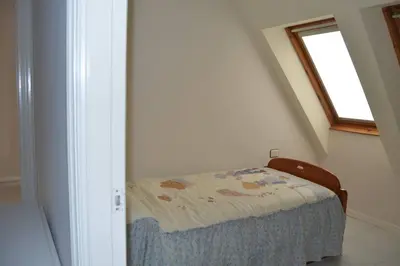 a small bedroom with a bed with a window at Precioso ático a pie de playa, en Miño. in Miño