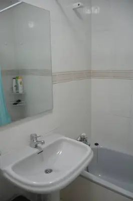 a bathroom with a sink and a tub and a mirror at Precioso ático a pie de playa, en Miño. in Miño
