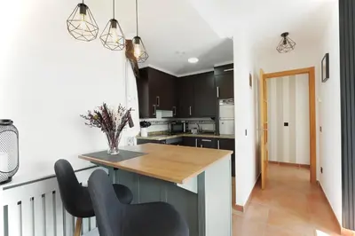 a kitchen with a wooden counter and black cabinets at ESTRELLA de RIBADEO in Ribadeo