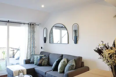 a living room with a couch and two mirrors at ESTRELLA de RIBADEO in Ribadeo