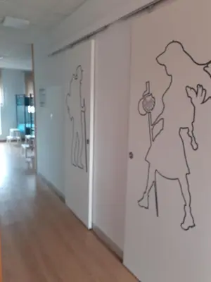 a hallway with a wall with drawings on it at ALBERGUE LEMAVO in Monforte de Lemos