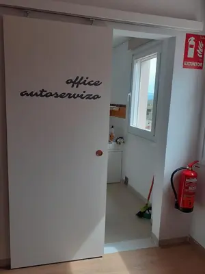a room with a fire extinguisher sign on the wall at ALBERGUE LEMAVO in Monforte de Lemos