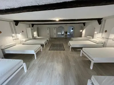 a room with white beds and wooden floors at HOSTEL PORTON in Lugo