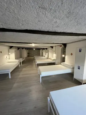 a room with white beds and wooden floors at HOSTEL PORTON in Lugo
