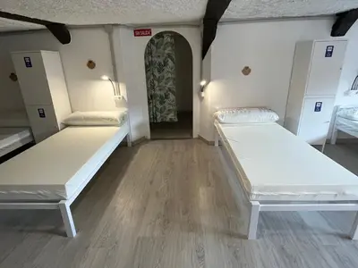 two beds in a room with a hallway at HOSTEL PORTON in Lugo