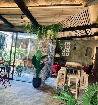a patio with a table and chairs and a stone wall at HOSTEL PORTON in Lugo
