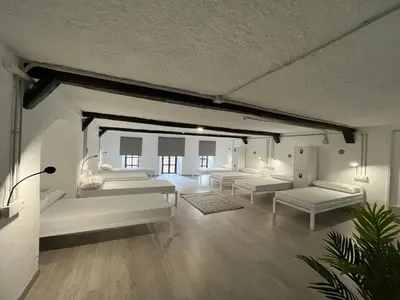 a living room with white couches and tables at HOSTEL PORTON in Lugo
