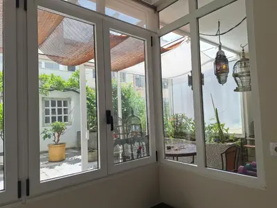 a room with three windows with views of a patio at MAXIMO CONFORT in Lugo