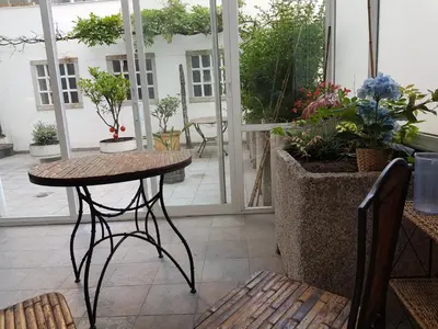 a patio with a table and some potted plants at MAXIMO CONFORT in Lugo