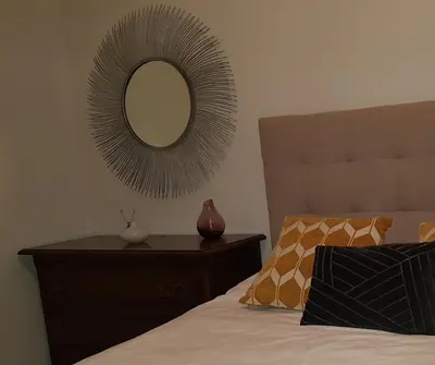 a mirror on a wall above a bed with a dresser at MAXIMO CONFORT in Lugo