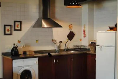 a kitchen with a washing machine and a refrigerator at Apartamentos Rurales Ca Lulón in Navelgas