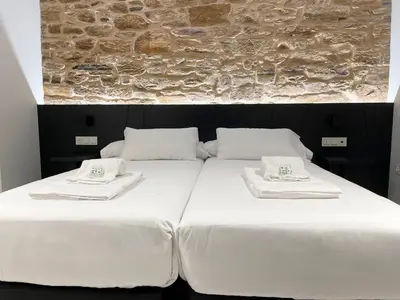 a large bed with white sheets and towels on it at Ultreia Seven Rooms by Adeloló in Santiago de Compostela