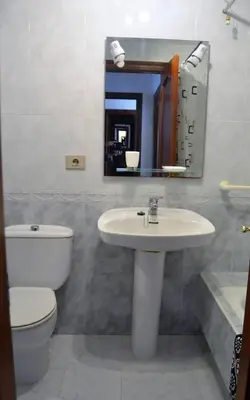 a bathroom with a sink and a toilet and a mirror at Precioso apartamento de 3 habitaciones en Cabañas. in Cabañas