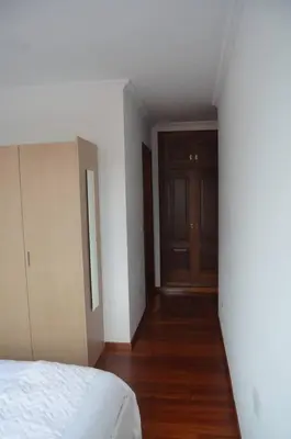 a bedroom with a white bed and a wooden floor at Precioso apartamento de 3 habitaciones en Cabañas. in Cabañas