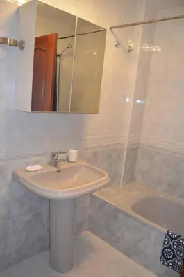 a bathroom with a sink and a mirror and a tub at Precioso apartamento de 3 habitaciones en Cabañas. in Cabañas