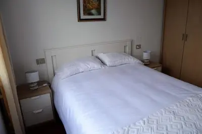 a bedroom with a large white bed with two night stands at Precioso apartamento de 3 habitaciones en Cabañas. in Cabañas