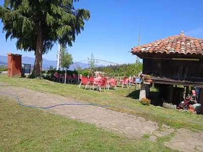 a yard with a house with a blue hose at Casa Faruxo in Cangas del Narcea