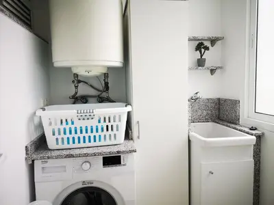 a laundry room with a washing machine and a sink at Alojamientos Viveiro - Ático Playa de Covas in Viveiro