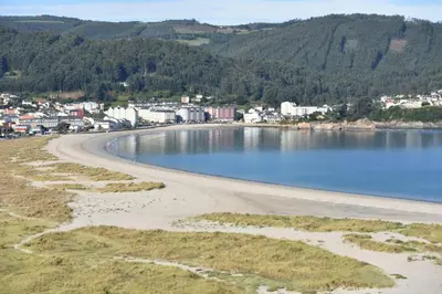 a view of a beach with a town in the background at Alojamientos Viveiro - Ático Playa de Covas in Viveiro
