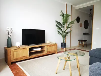 a living room with a television on a wooden entertainment center at Alojamientos Viveiro - Ático Playa de Covas in Viveiro
