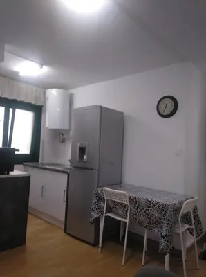 a small kitchen with a table and a refrigerator at Estudio. Sada, A Coruña. in Sada