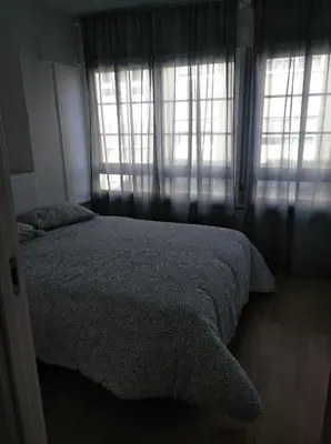 a bedroom with a bed and two windows at Estudio. Sada, A Coruña. in Sada