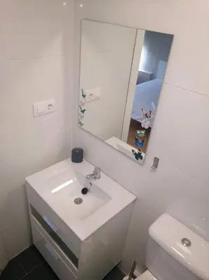 a white bathroom with a sink and a mirror at Estudio. Sada, A Coruña. in Sada