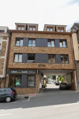 a brick building with a parking garage in front of it at Apartamentos Casa Paulino in Taramundi