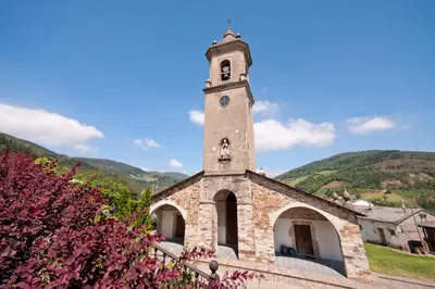 a church with a tower with a clock on it at Apartamentos Casa Paulino in Taramundi