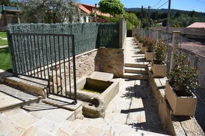 a row of benches next to a fence with flowers at A Casa Romeu in Santiago de Compostela