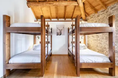 two bunk beds in a room with wooden ceilings at A Casa Romeu in Santiago de Compostela