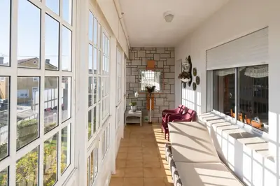 a large room with windows and chairs on a balcony at Casa Jesús in A Capela
