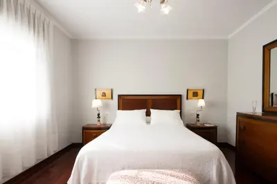 a bedroom with a large white bed with two night stands at Casa Jesús in A Capela