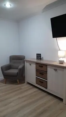 a living room with a television and a chair at Apartamento a Carballeira in Lugo