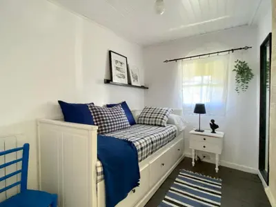a bedroom with a bed with blue and white pillows at RIBEIRA SACRA La Imperfecta in Ferreira de Panton