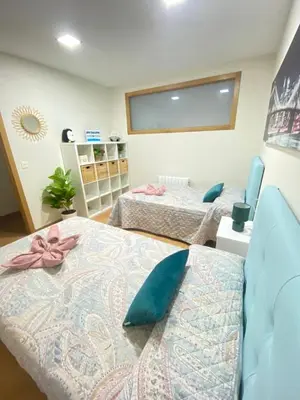 a room with two beds and a large window at APTO CÉNTRICO ARENAL FAMILY, PARKING GRATIS in Lugo